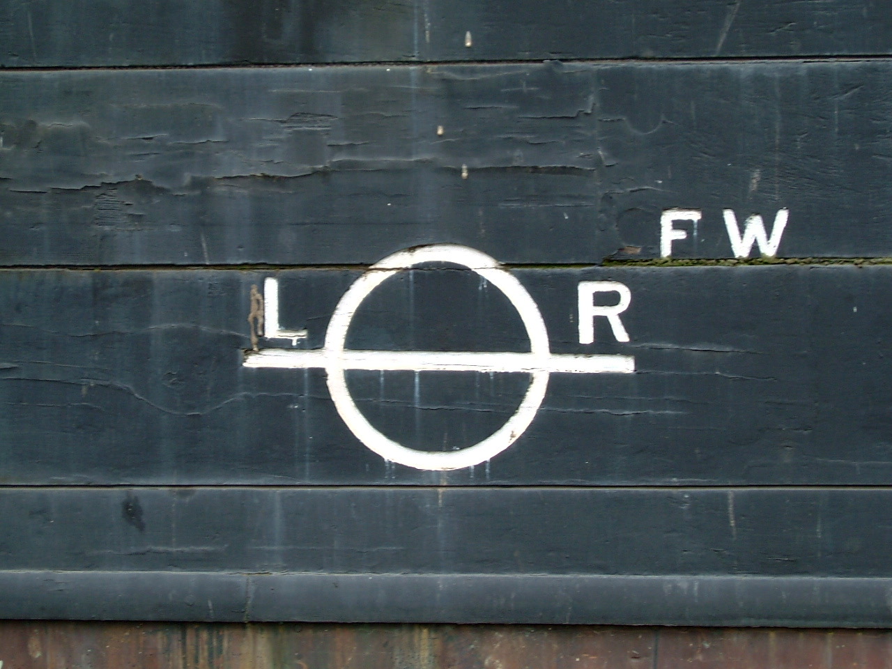 A Lloyd's Register load line disc painted on a wooden hull